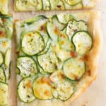 Top view of a slice of pizza with zucchini.
