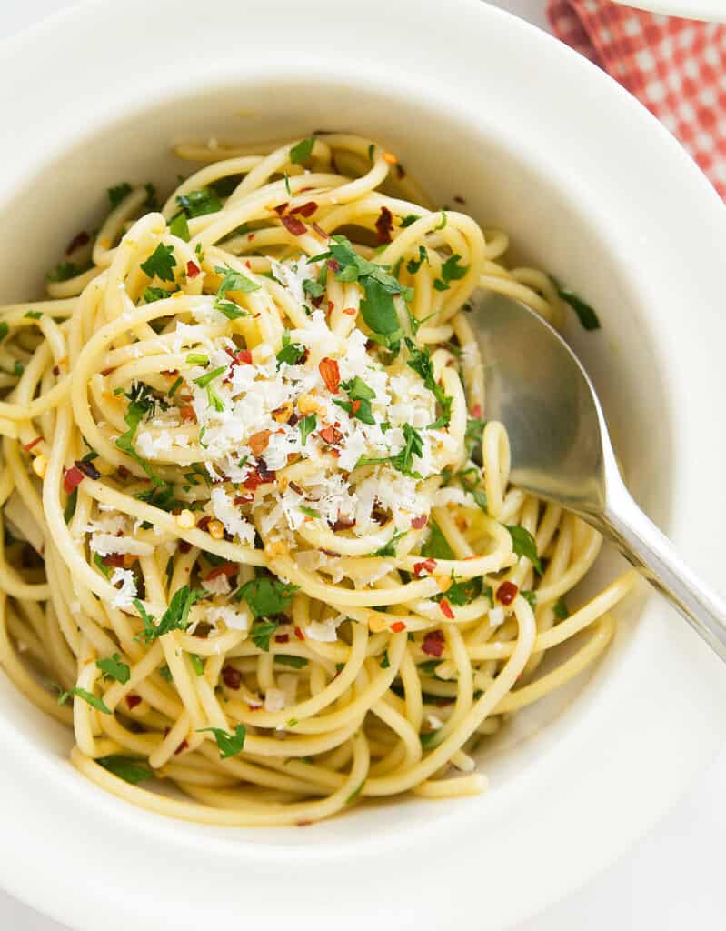 가장 인기 있는 이탈리아 파스타 요리법 중 하나인 올리브 오일과 마늘을 곁들인 스파게티로 가득 찬 흰색 그릇의 최고 전망.