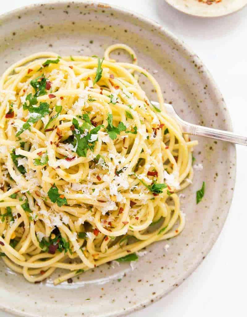 Top view of a plate full of spaghetti aglio e olio, a popular Italian pasta recipes.