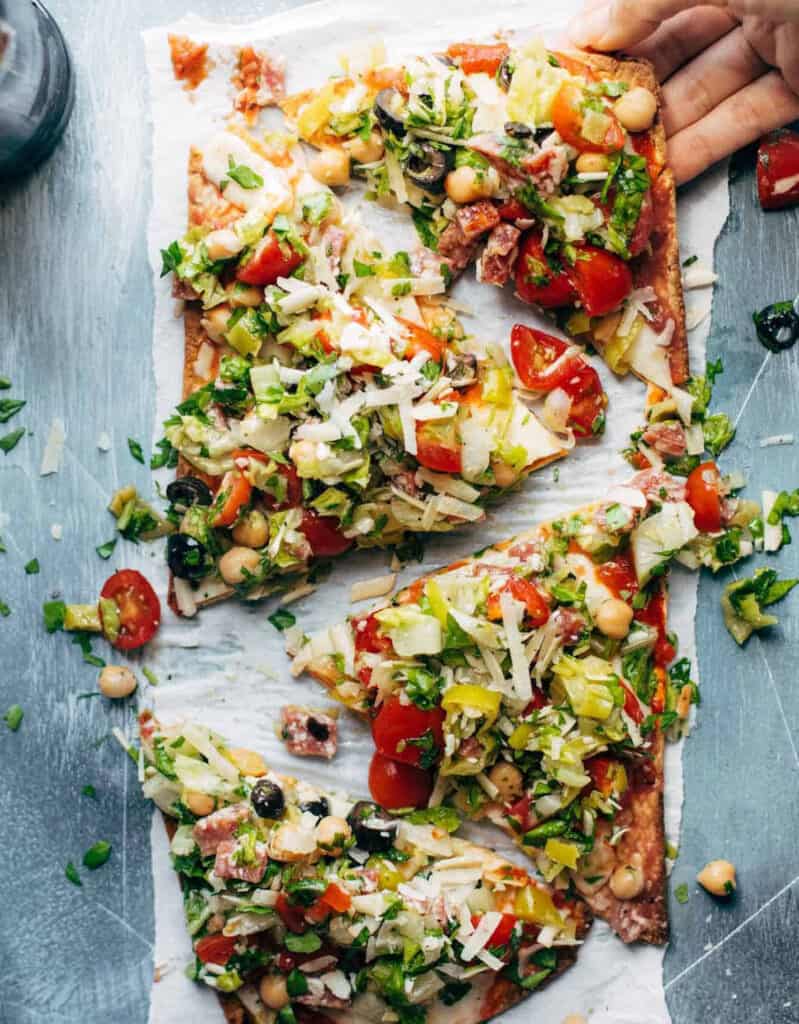 Four slices of veggie pizza over a white sheet of baking paper.