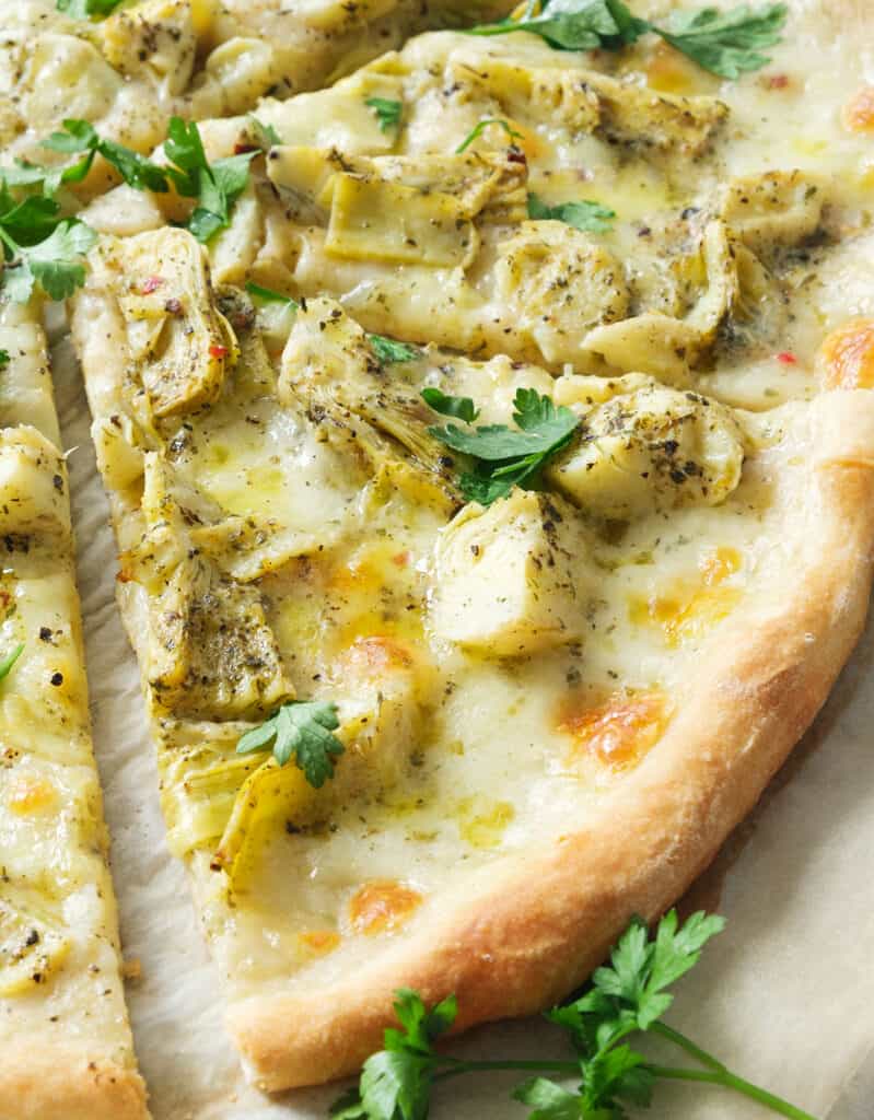 Close-up of a crispy slice of pizza with artichokes.
