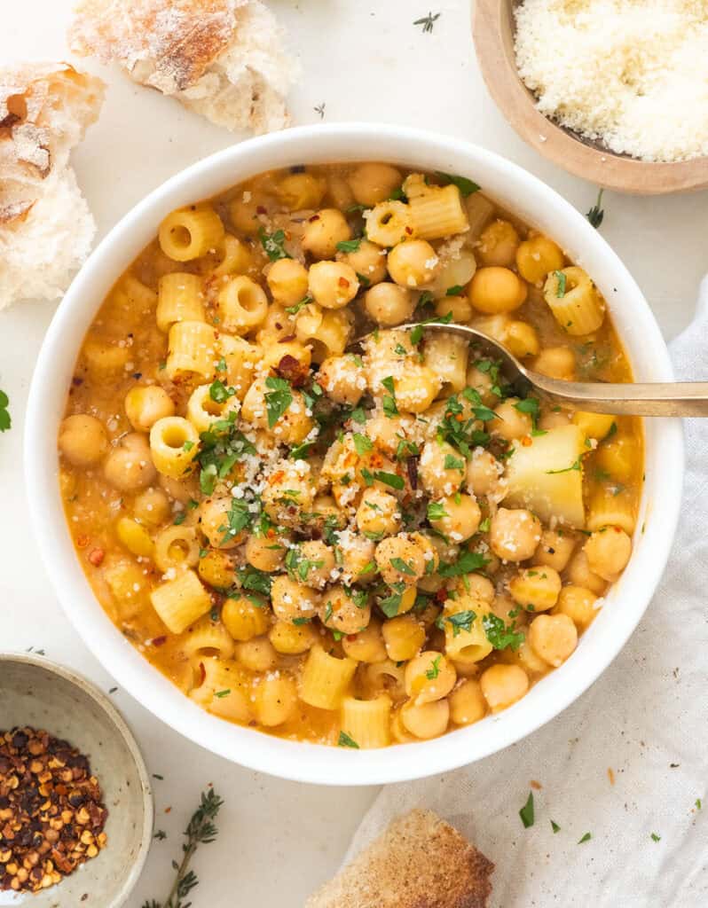 White bowl full of chickpea paste with spoon.