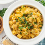 Top view of a white bowl full of pasta with chickpeas aka Italian pasta e ceci.