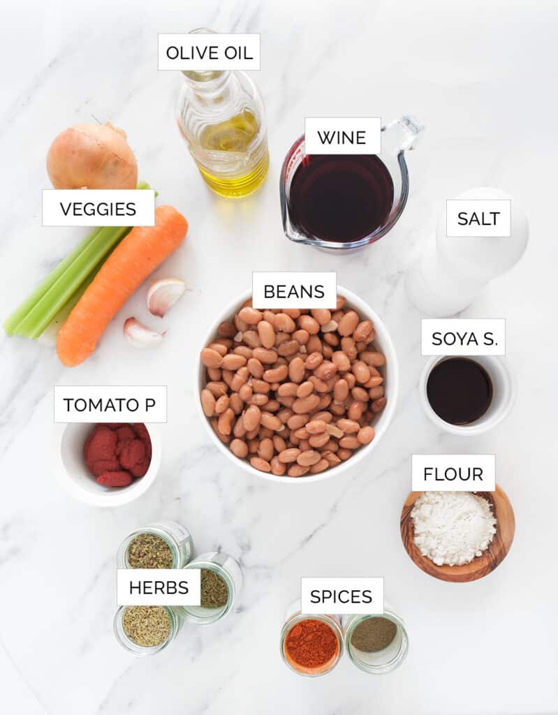 Top view of the ingredients to make this bean stew over a white background.