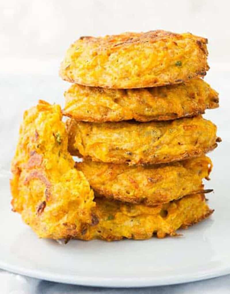 Crispy squash fritters over a white background.