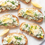 Artichoke bruschetta on a marble plate.