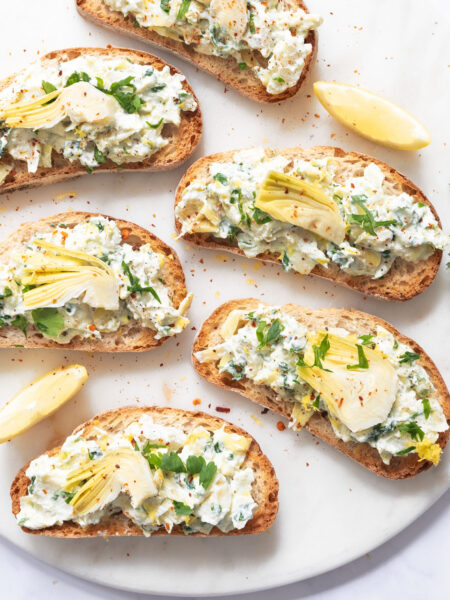 Artichoke bruschetta on a marble plate.