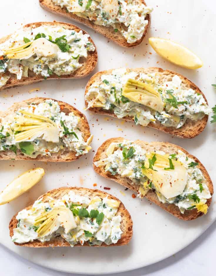 Artichoke bruschetta on a marble plate.