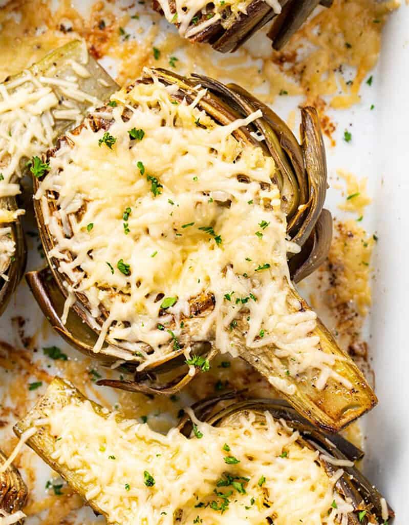 Top view of roasted artichokes halves full of creamy cheese.