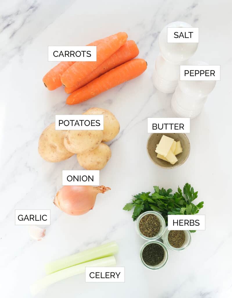 Top view of the ingredients to make carrot potato soup over a white background.