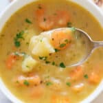 Top view of a white bowl full of carrot potato soup.