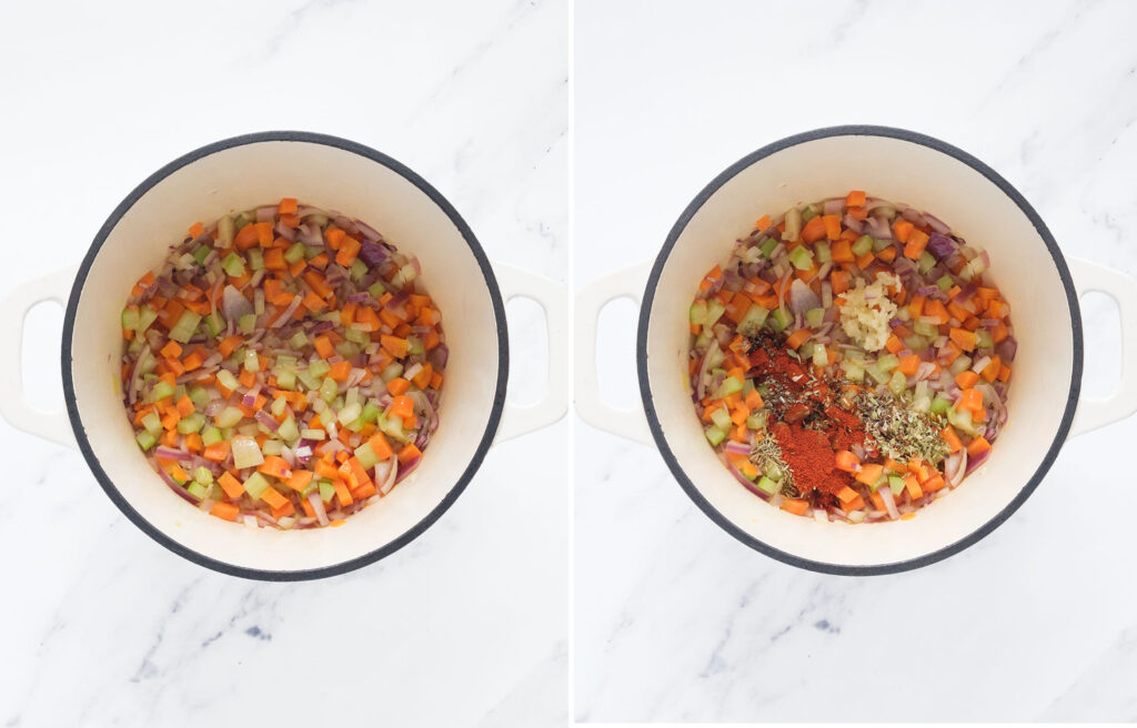 Top view of a white cast iron full of diced carrot, onion, celery, garlic and spices.