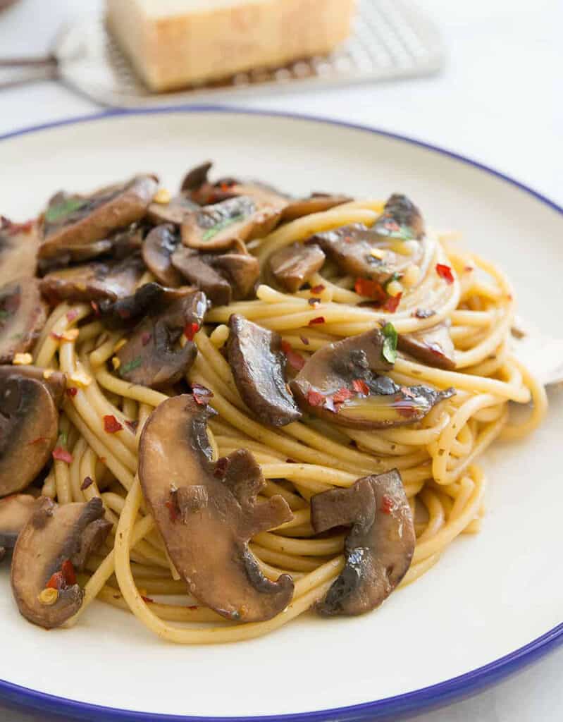 Close-up of a plate full of spaghetti with mushrooms.