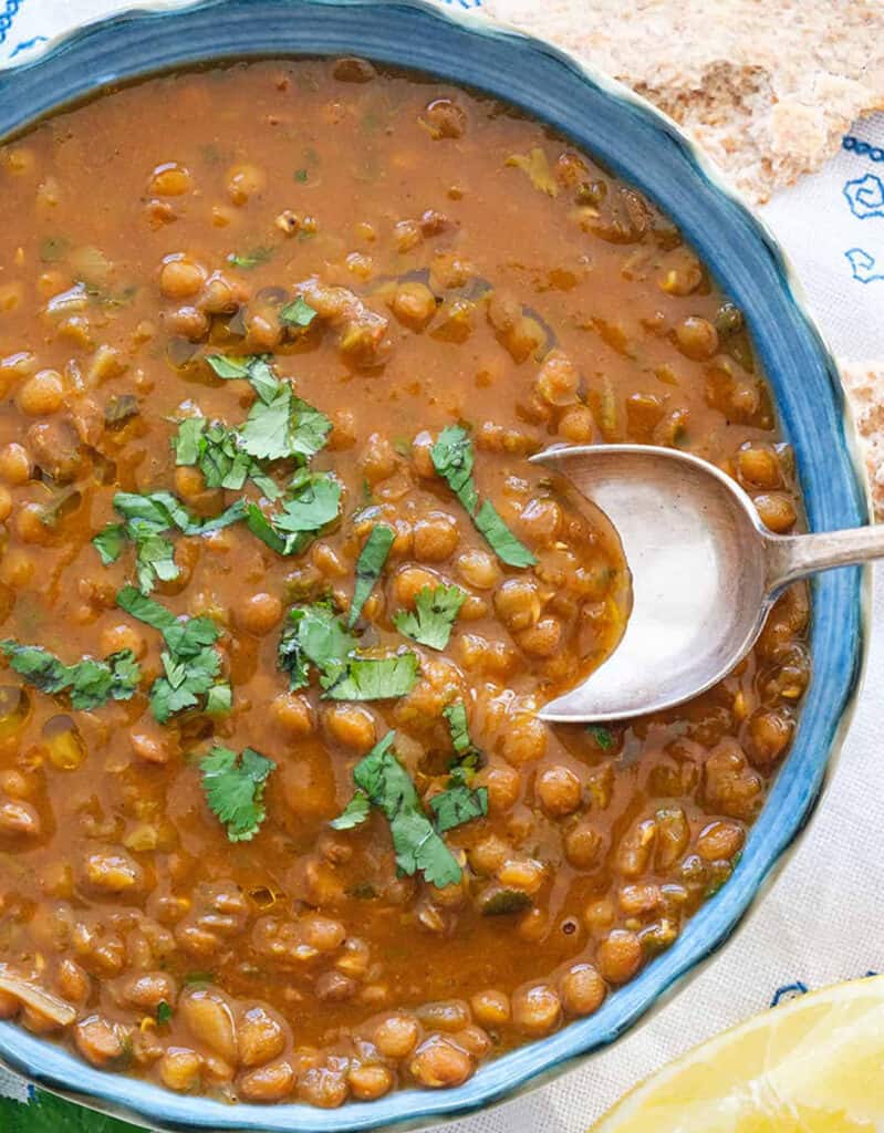 Top top view of a blue bowl full of thick lentil soup, one of my best meatless meals.