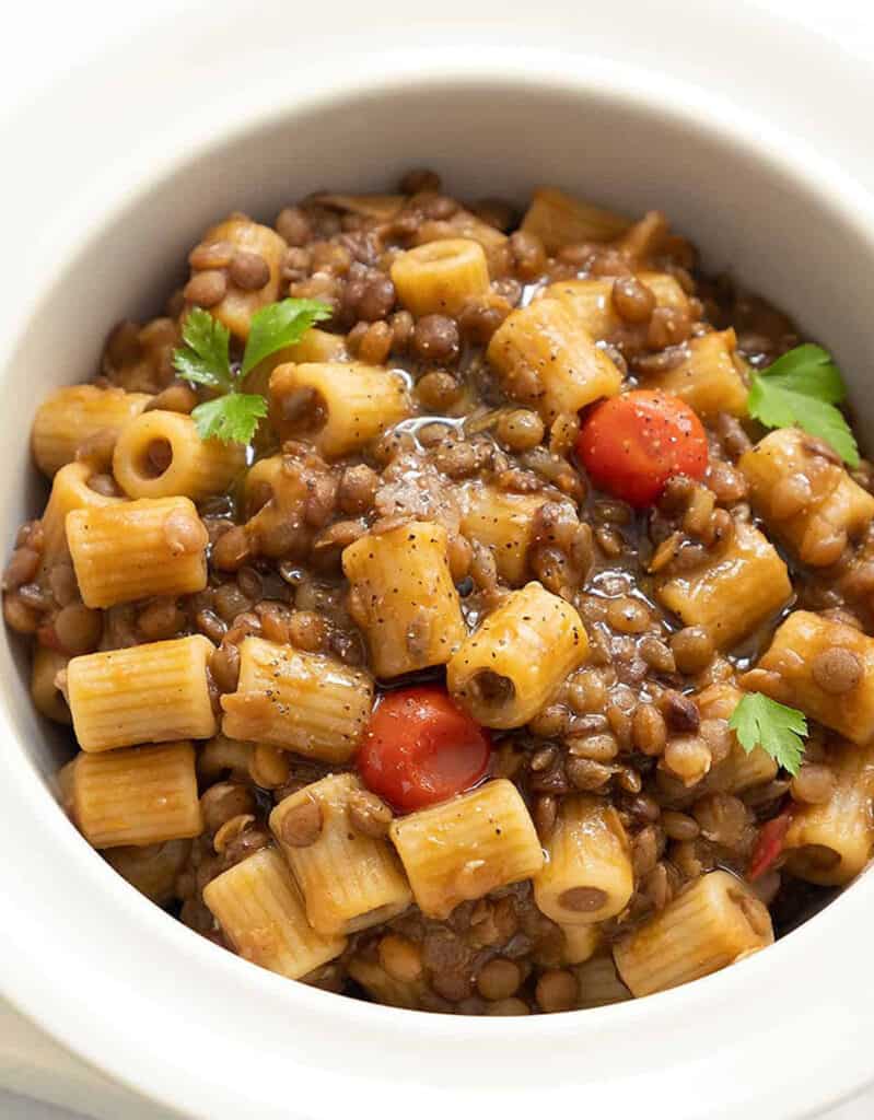 Close-up of a white bowl full of pasta with lentils, one of the best meatless recipes.