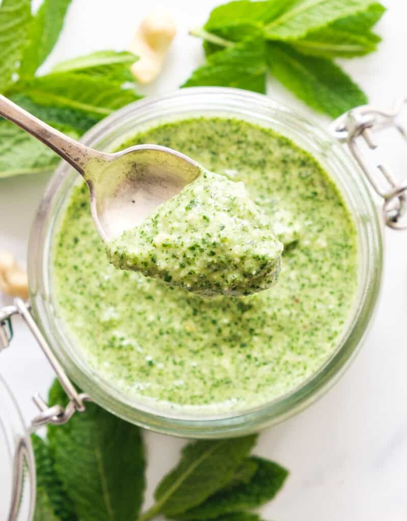 Top view of a spoon full of mint pesto.