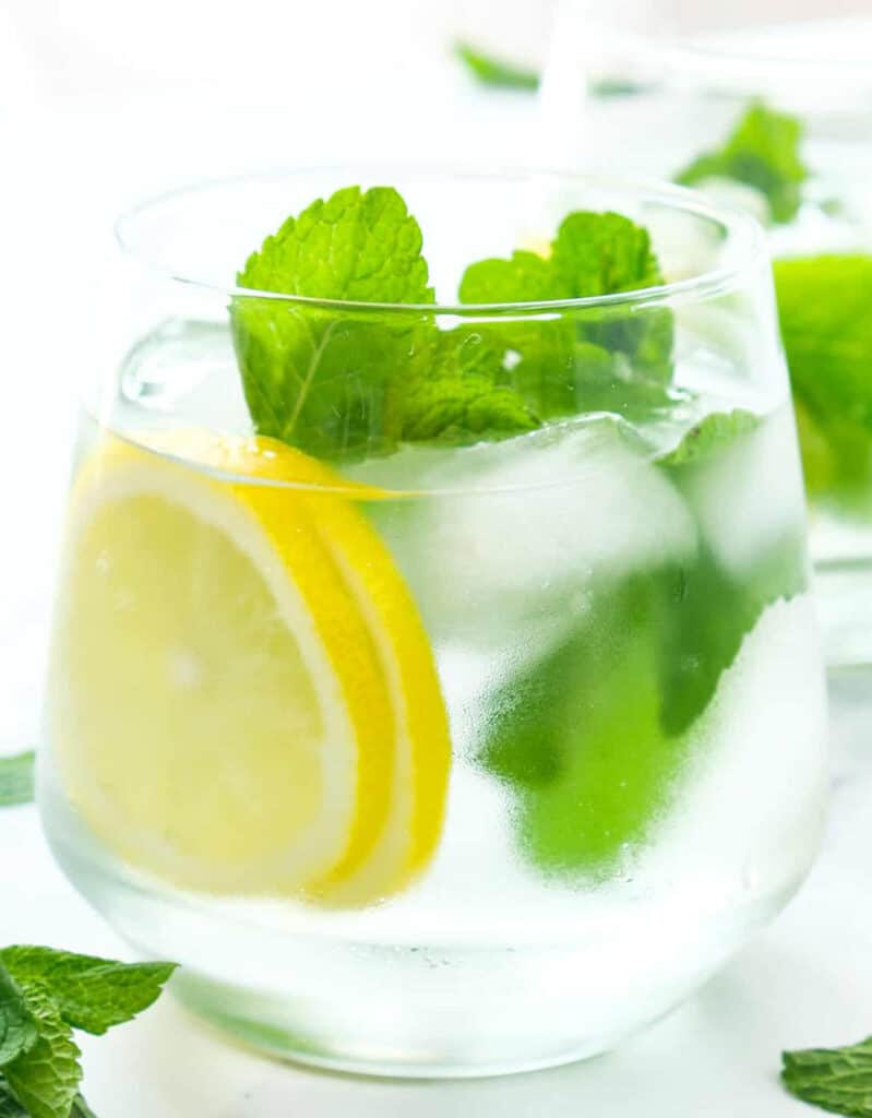 Close-up of a glass full of ice, water, mint leaves and lemon slices. One of my fav mint recipes in summer.