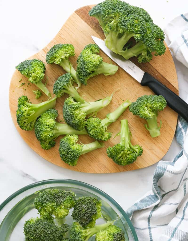 Top view of a wooden board with broccoli florets.