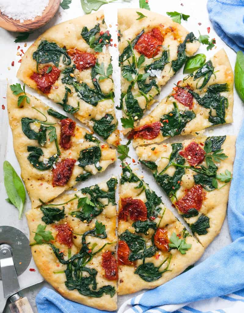 Top view of one of my fav focaccia toppings made with sun dried tomatoes and wilted spinach.