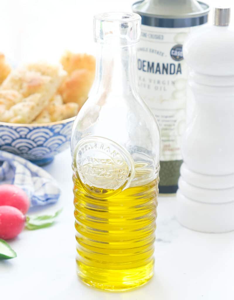 Close-up of a white bottle full of extra virgin olive oil, the main ingredient to make pinzimonio.