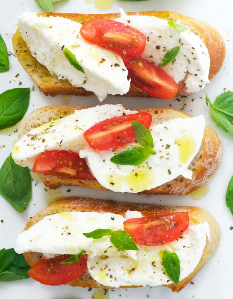 Top view of mozzarella bruschetta with cherry tomatoes, one of the best mozzarella recipes.