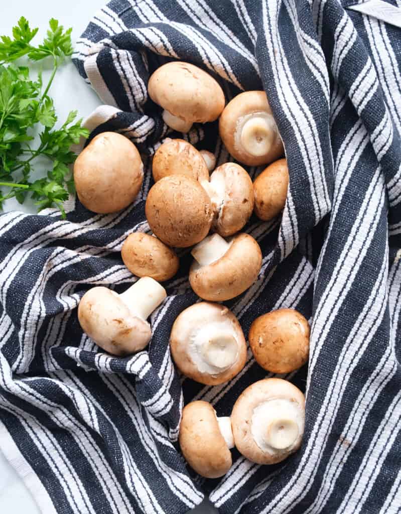 검은색과 흰색 주방 수건에 일부 크레미니 버섯의 상위 뷰.
