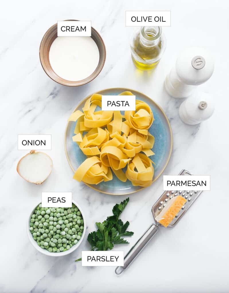 The ingredients to make this pappardelle pasta are arranged over a white background.