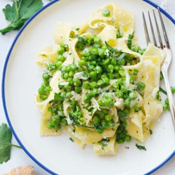 Top view of plate full pappardelle pasta with peas.