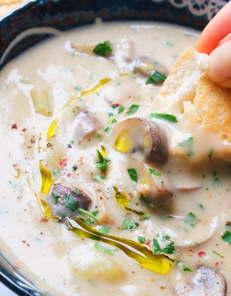 A piece of crusty bread dipped into the luscious potato and mushroom soup drizzled with olive oil.