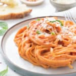 Close-up of a plate with spaghetti with tomato pasta sauce with cream cheese.