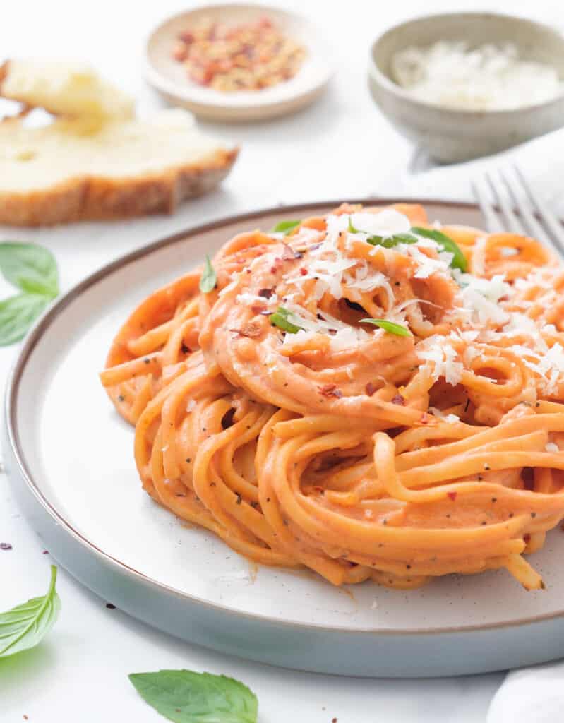 Close-up of a plate full of linguine with tomato pasta sauce with cream cheese.