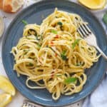 Top view of a blue plate full of lemon garlic pasta.