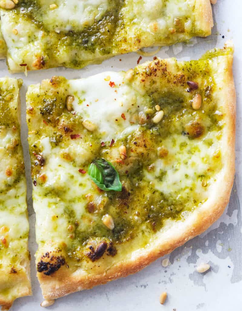 Top view of a slice of pesto pizza.