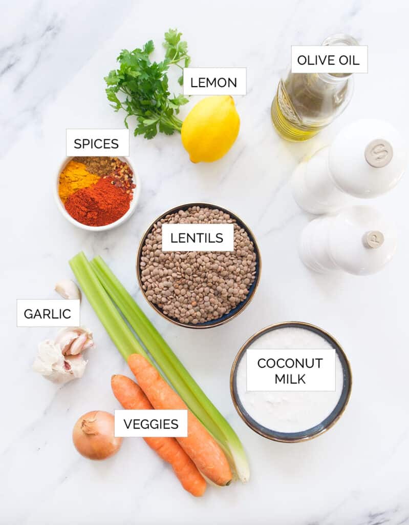Top view of the ingredients to make this spicy lentil soup over a white background.