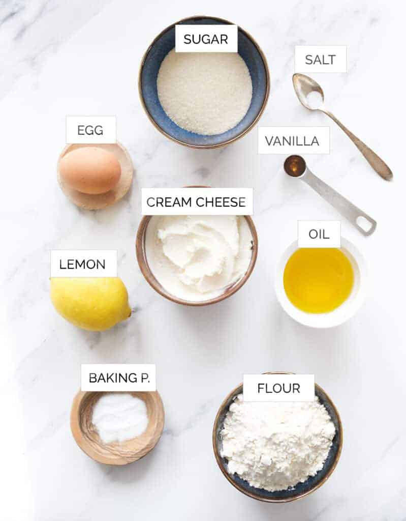 Top view of the ingredients to make cream cheese muffins over a white background.