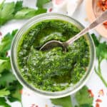 Top view of a glass jar full of parsley pesto.