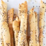 Top view of a bunch of crispy breadsticks with seeds.