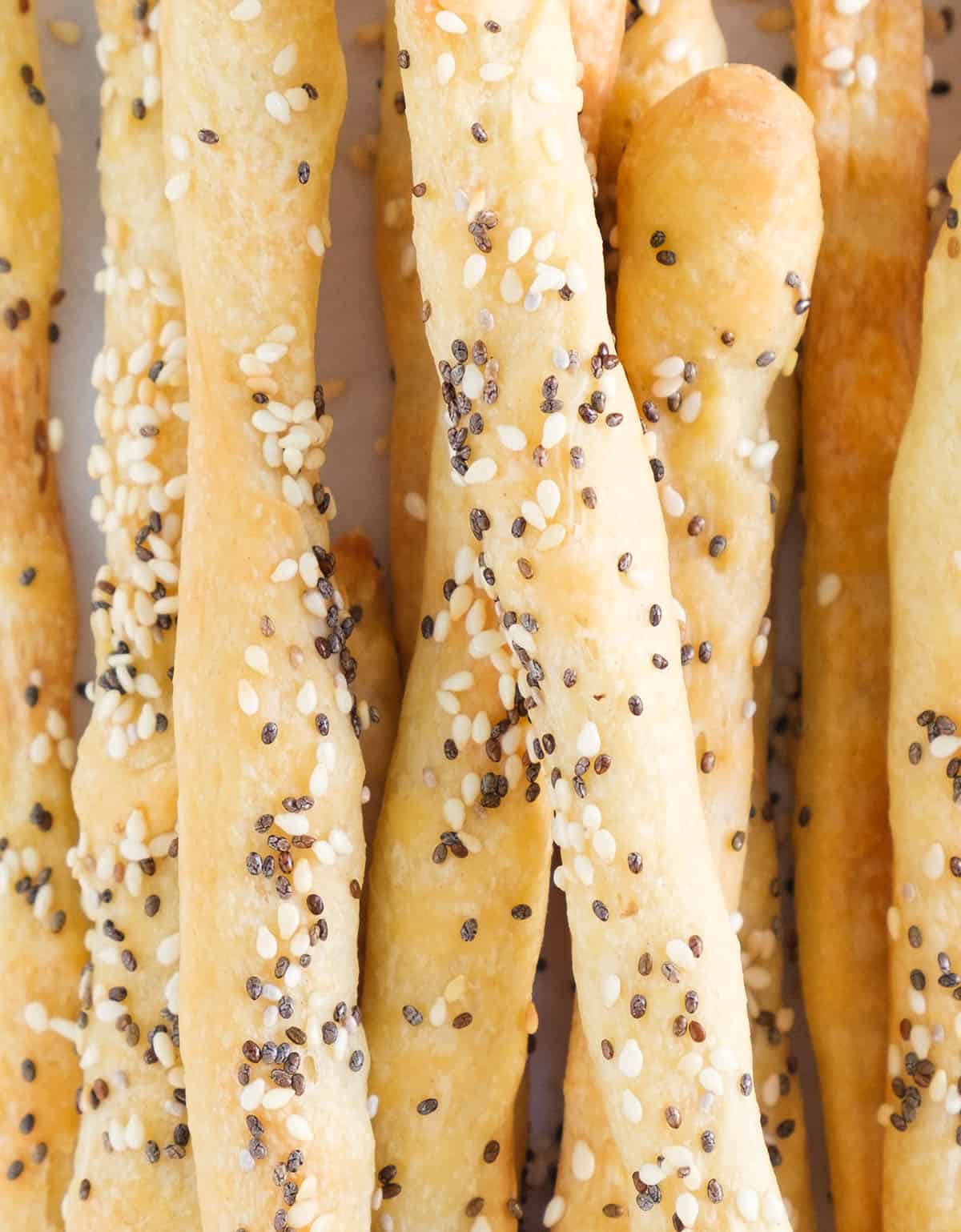 Close-up of a bunch of crispy breadsticks with seeds.