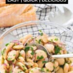A glass bowl full of white bean salad.