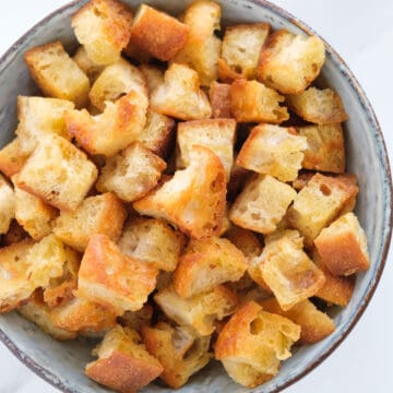 Top view of a bowl full of croutons made in a pan.