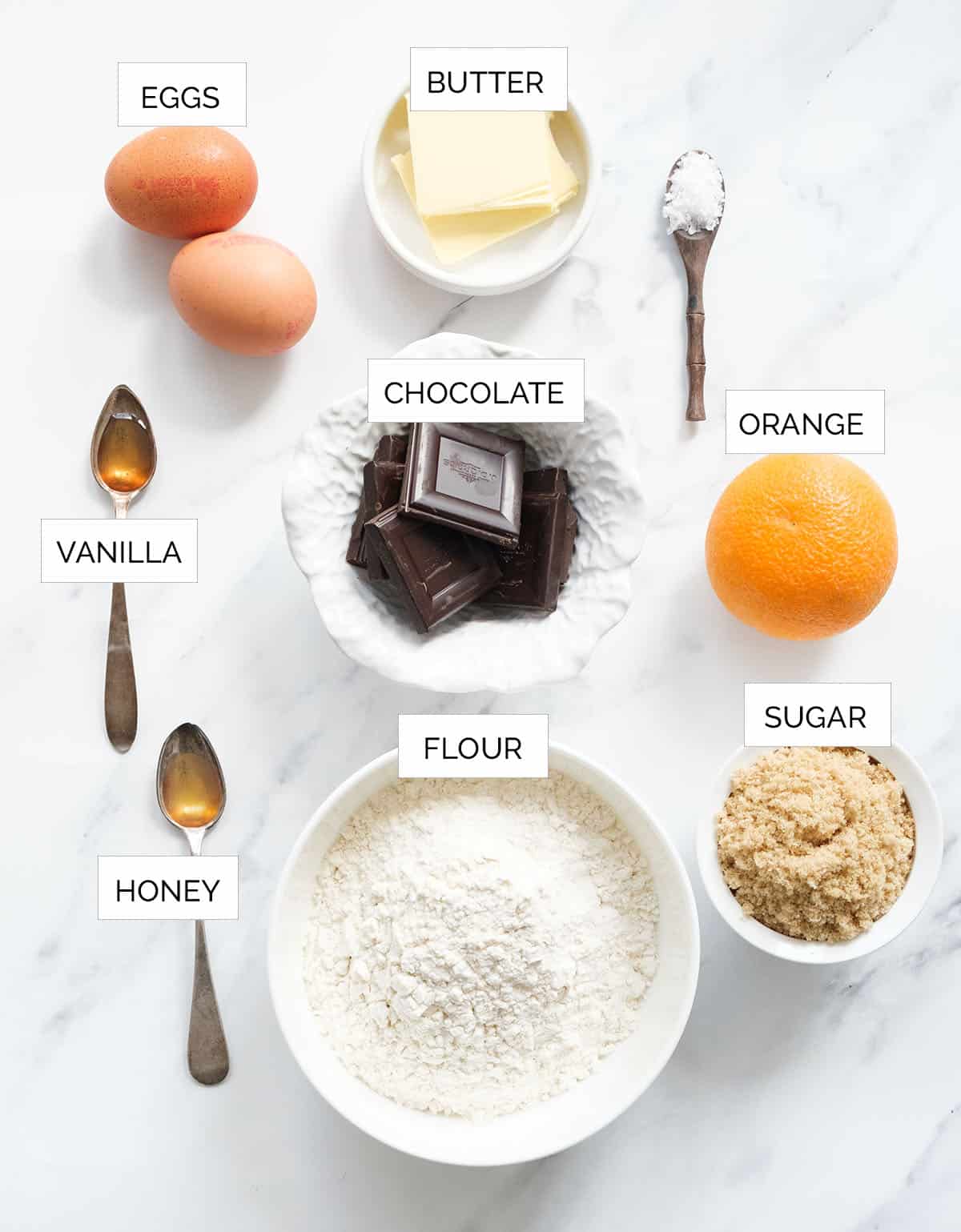 Top view of the ingredients to make chocolate biscotti over a white background.