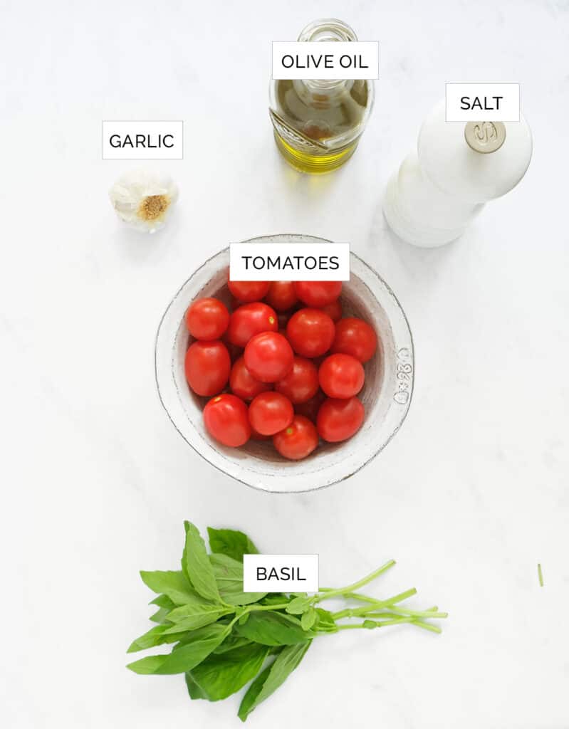 The ingredients to make this bruschetta dip are arranged over a white background.