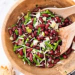 A wooden bowl full of kidney bean salad.