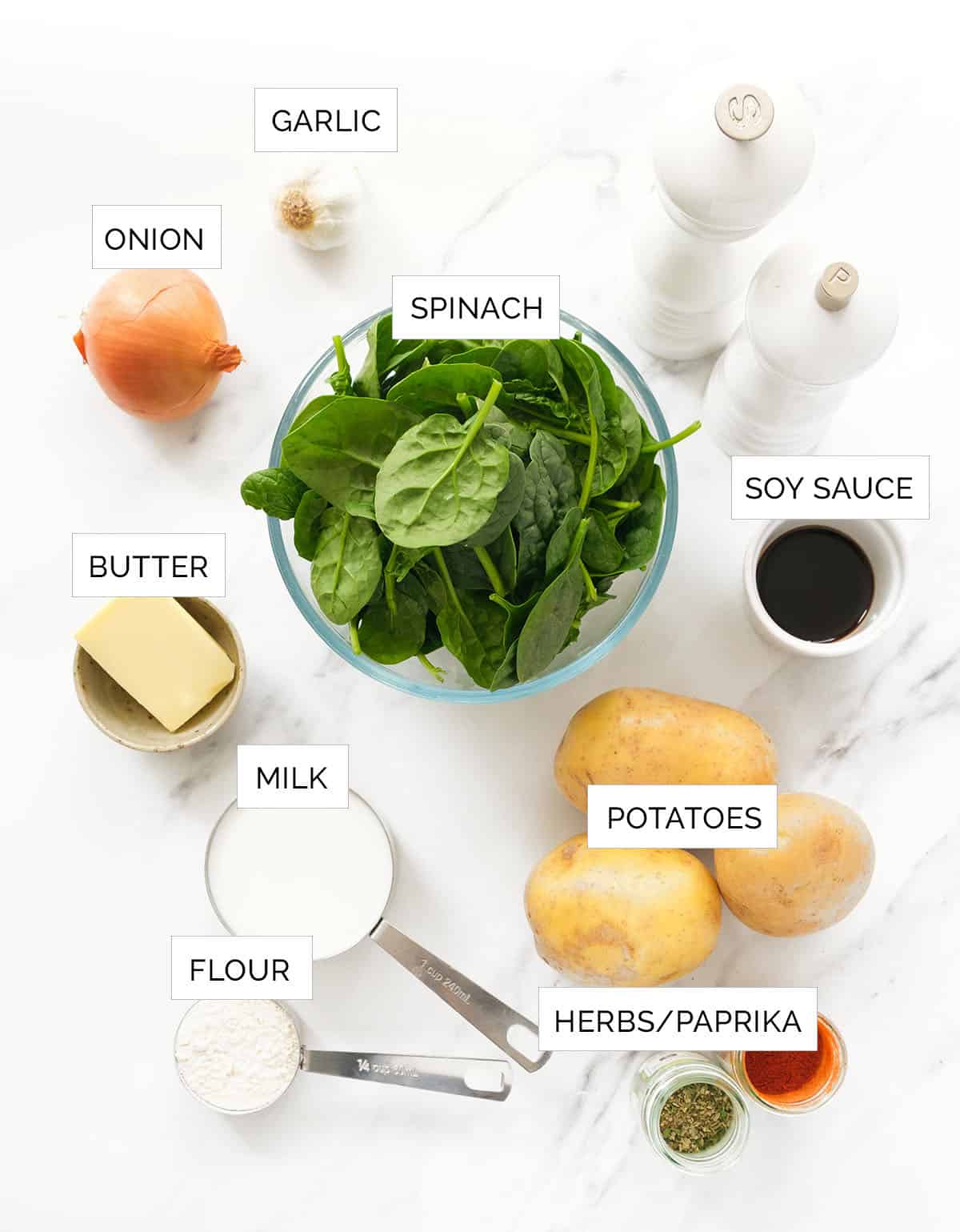 The ingredients to make this potato spinach soup are arranged over a white background.