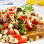 Close-up of a white plate full of cannellini bean salad.