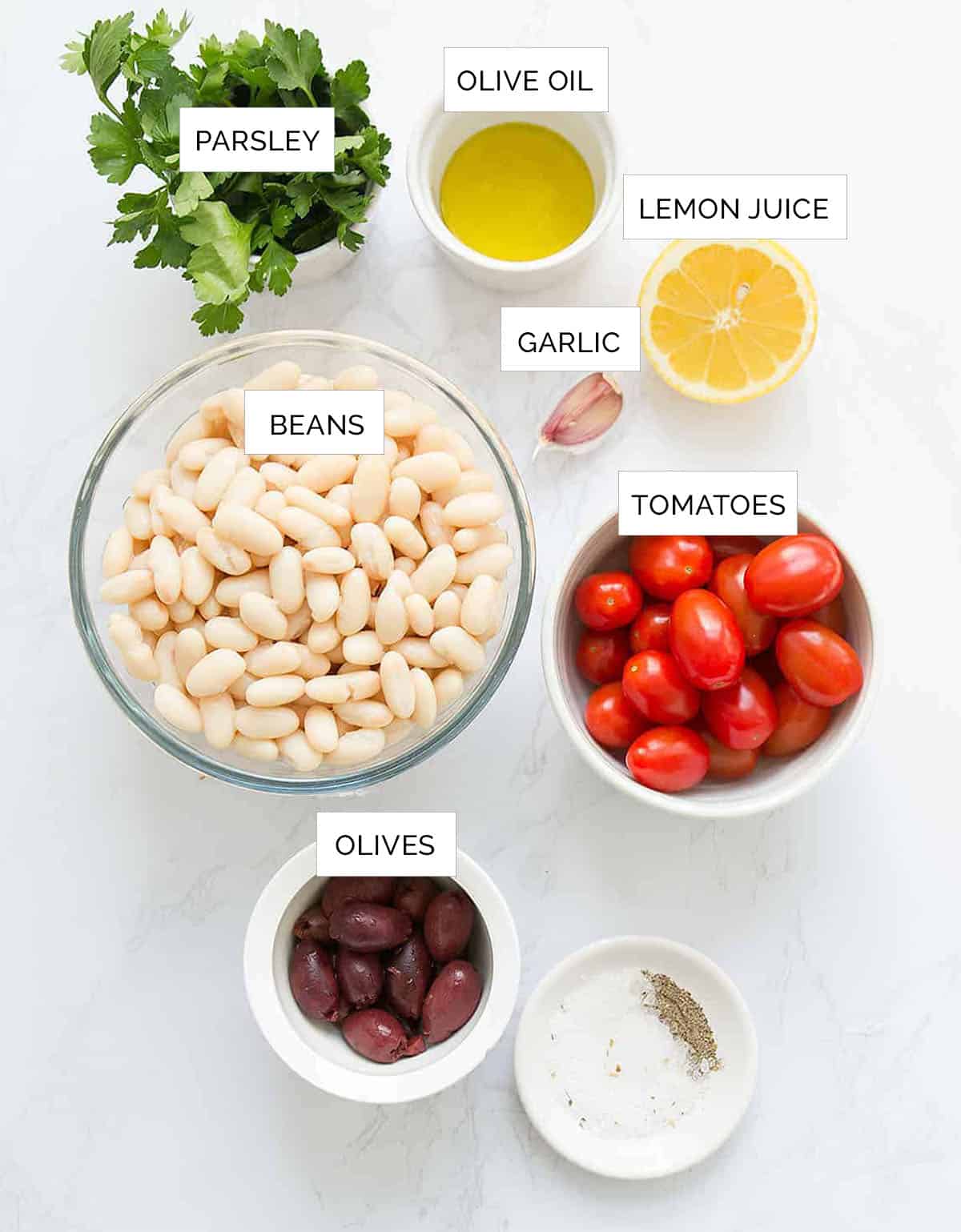 The cannellini bean salad ingredients are arranged over a white background.