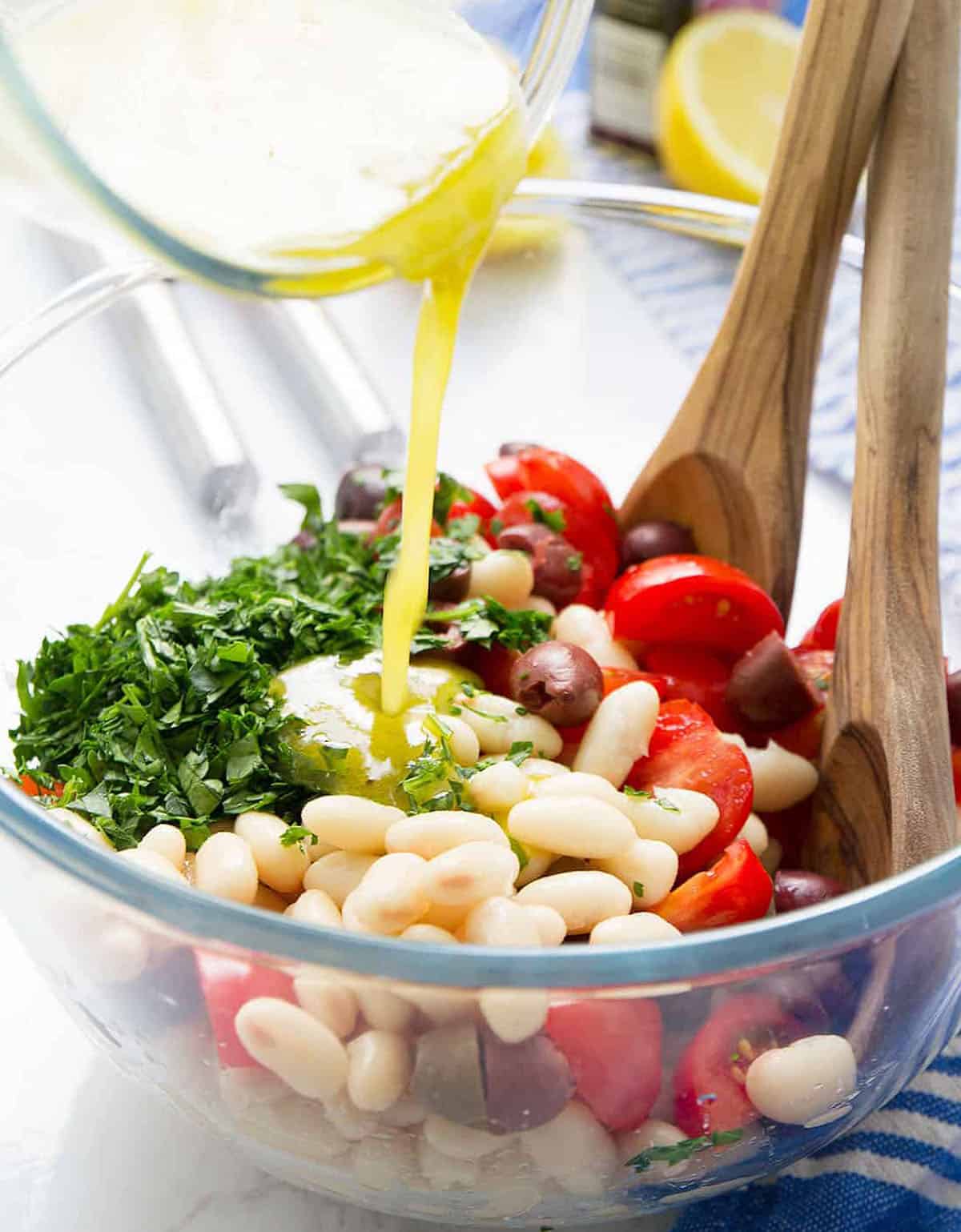 Close-up of a glass salad bowl full of cannellini bean salad.
