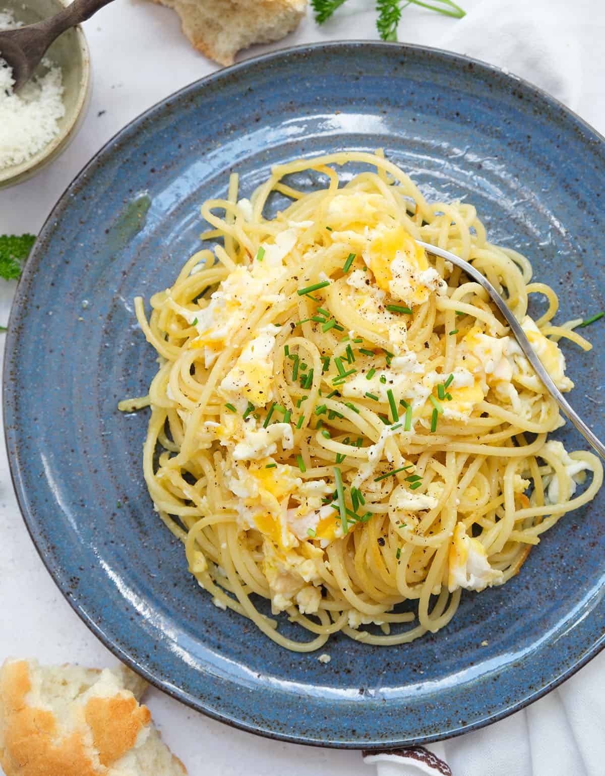 Top view of a blue plate full of fried spaghetti and scrambled eggs.