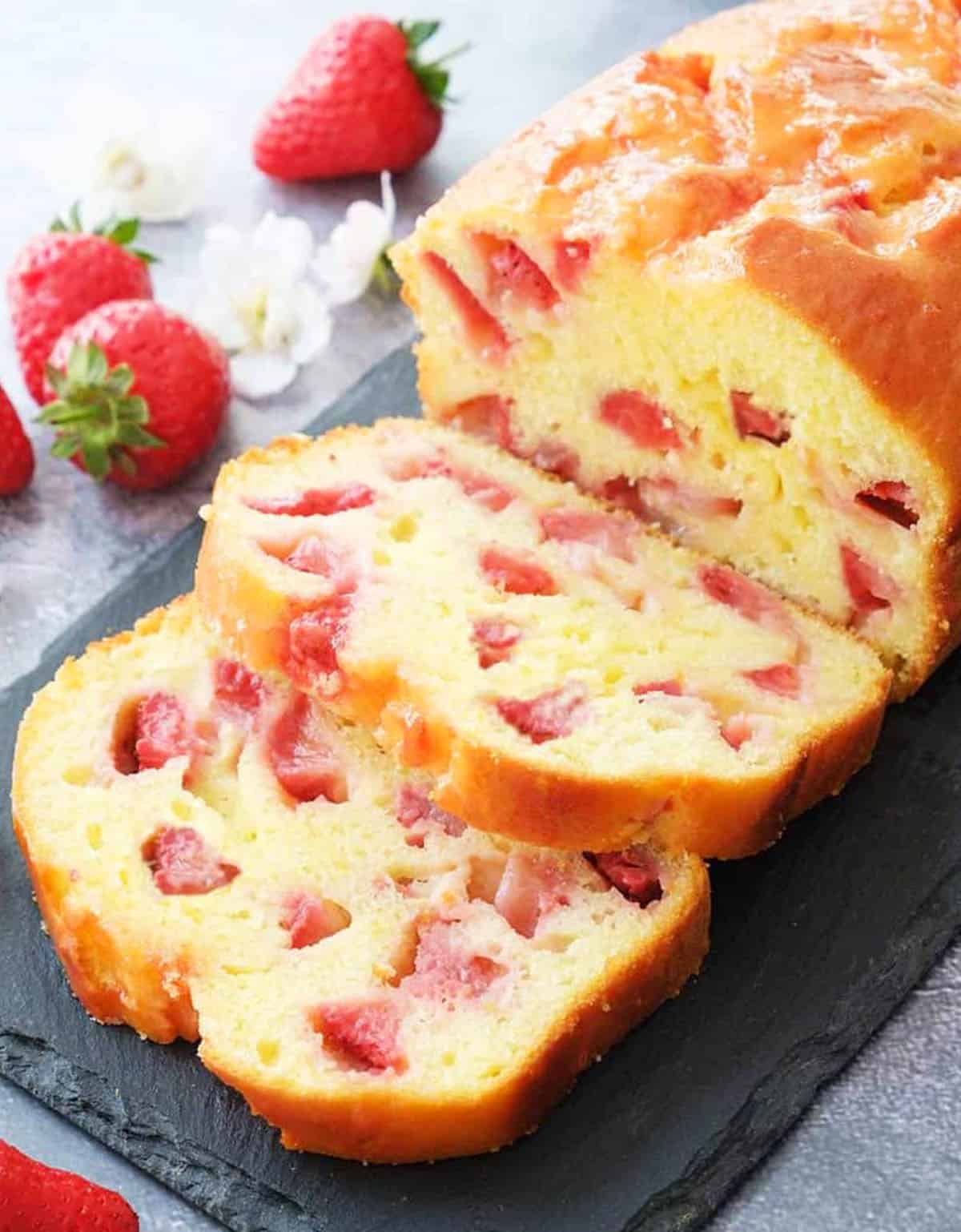 Strawberry bread cut into slices on a black slate tray.