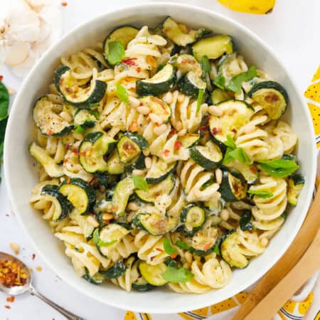Top view of a white salad bowl with zucchini pasta salad.